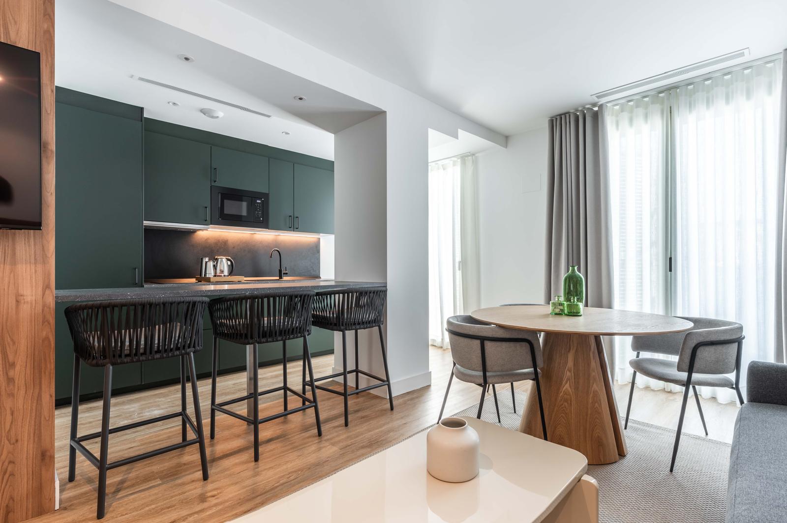Estudio boutique Cauce4 con cocina equipada, barra con taburetes y zona de descanso