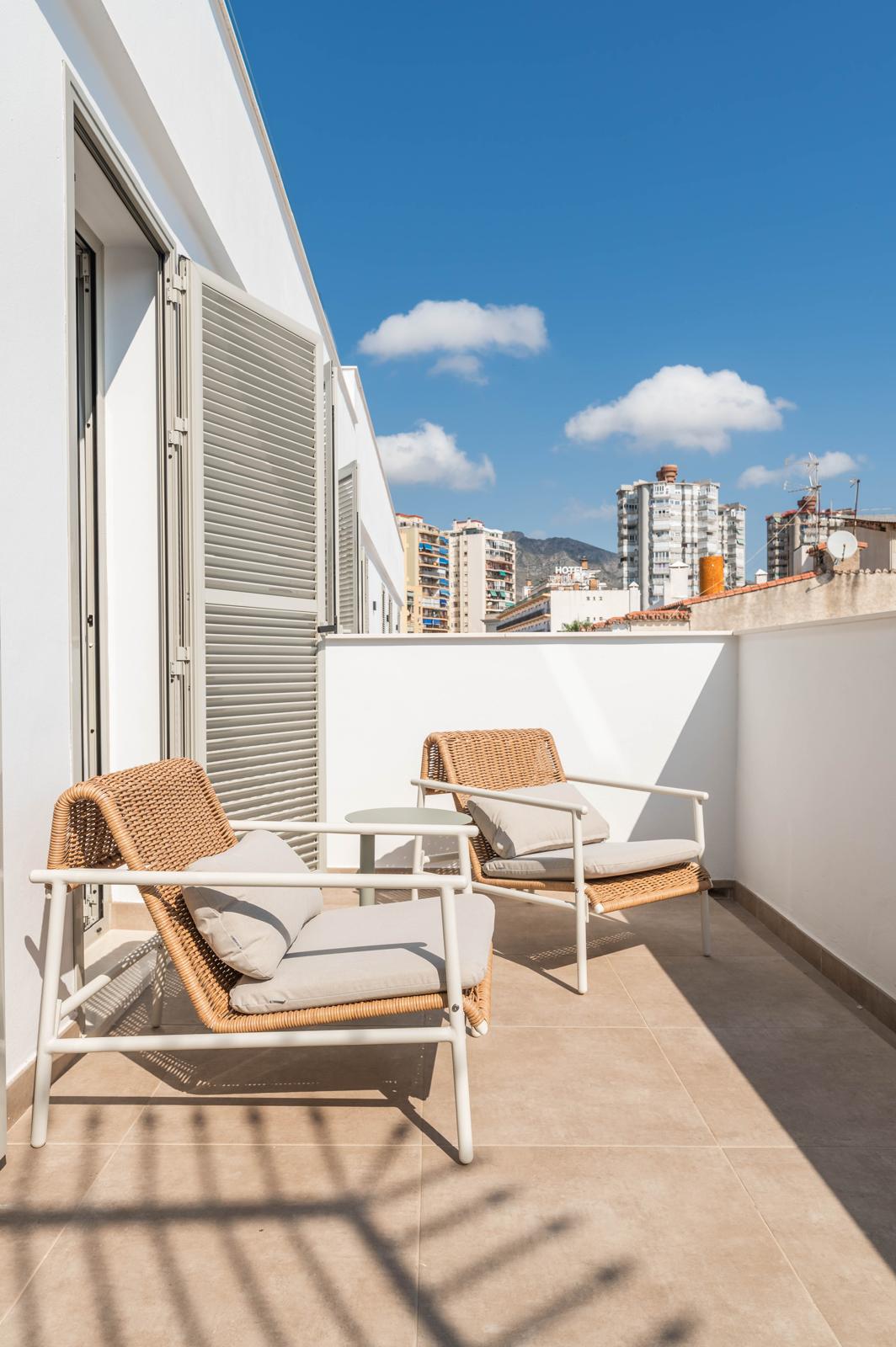 Terraza con sillón de mimbre en Cauce4