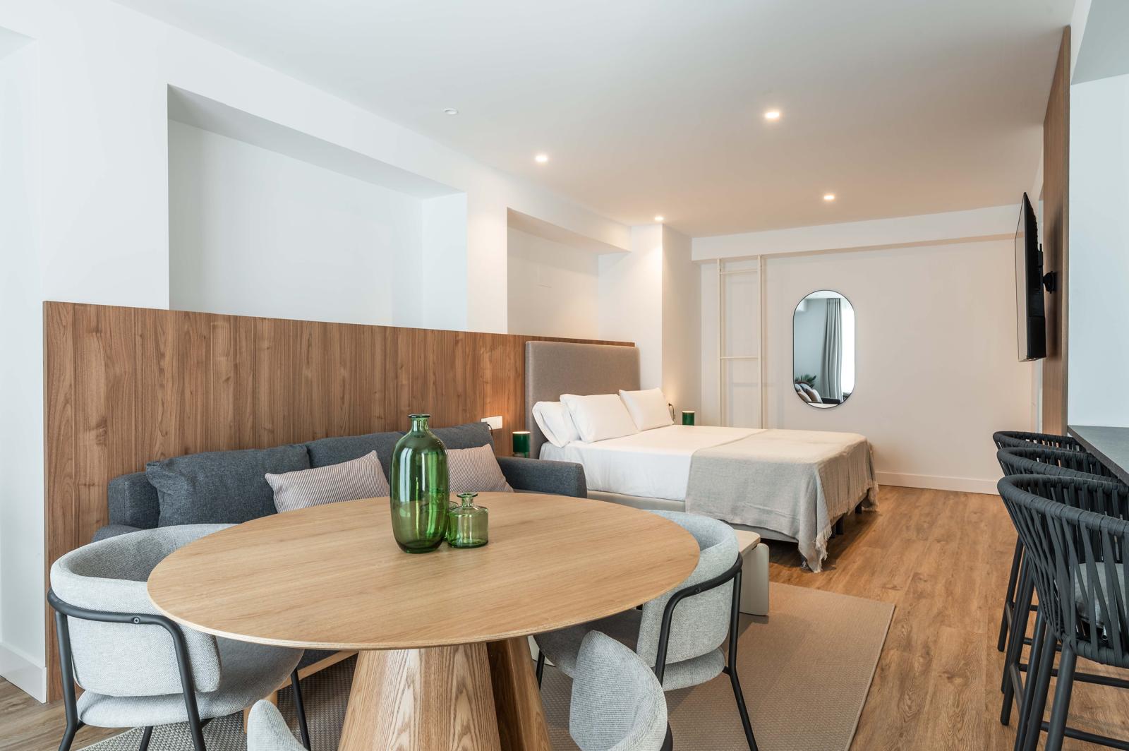 Suite Cauce4 con cama, sofá y amplia zona de estar luminosa