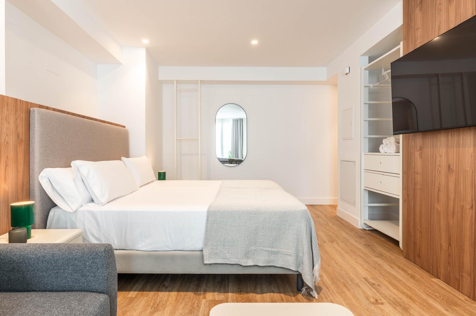 Habitación Cauce4 con cama de matrimonio, cabecero tapizado y armario