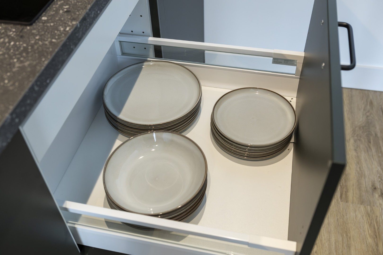 Vajilla de cerámica ordenada en un cajón de la cocina de Cauce4